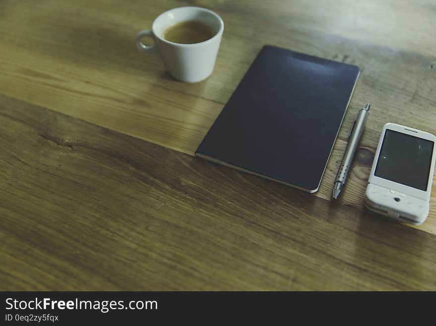 Black Table Computer Beside White Mug