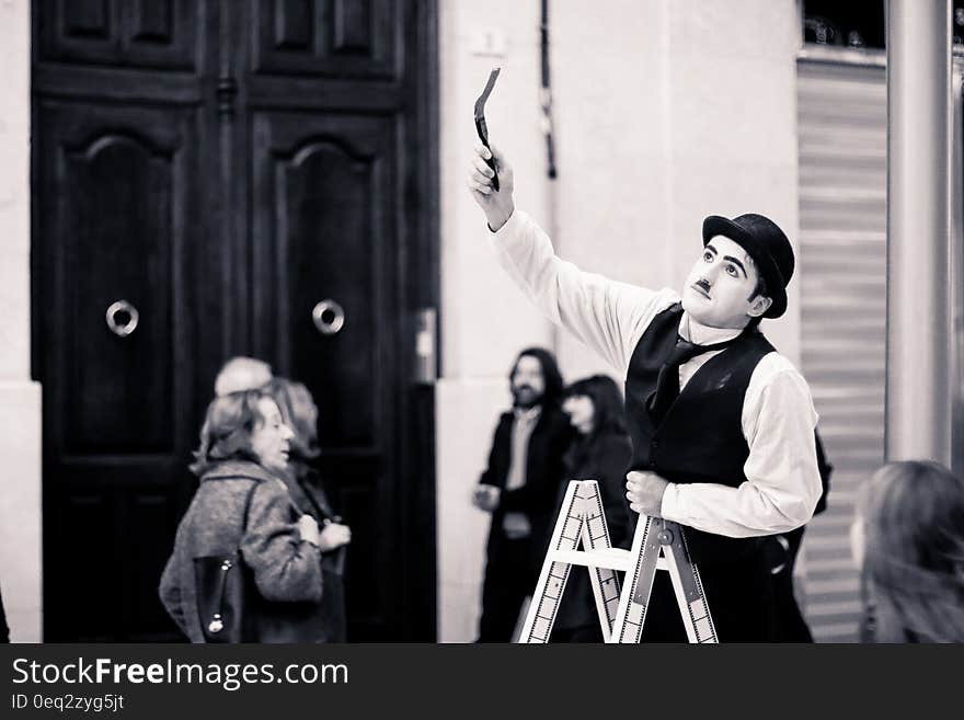 Oliver Hardy look alike on a ladder at the theater taking part in pantomime.