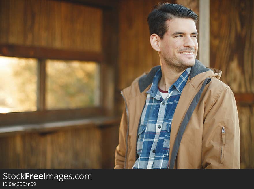 Young man in jacket looking back smiling. Young man in jacket looking back smiling