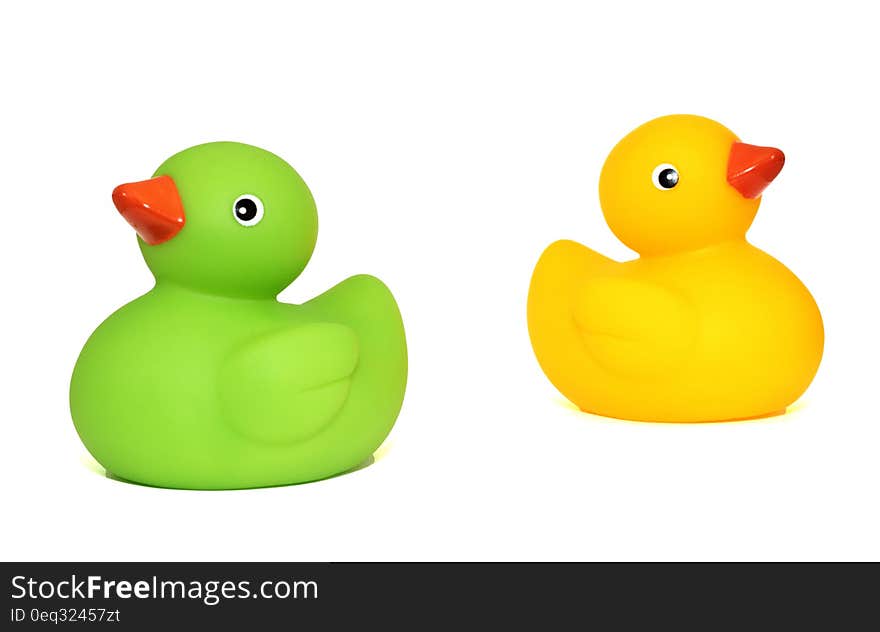 Yellow Duck Toy Beside Green Duck Toy