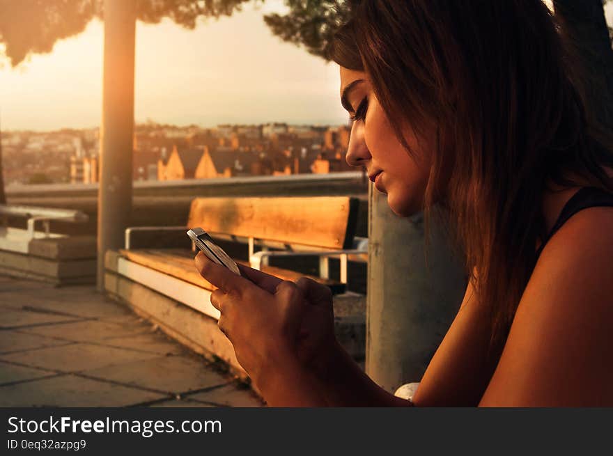 Woman With Black Dress Using a Smartphone