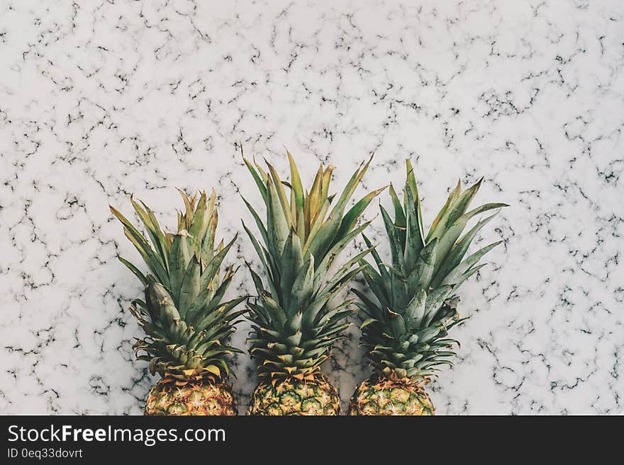 3 Pineapple Fruit on White and Grey Sand