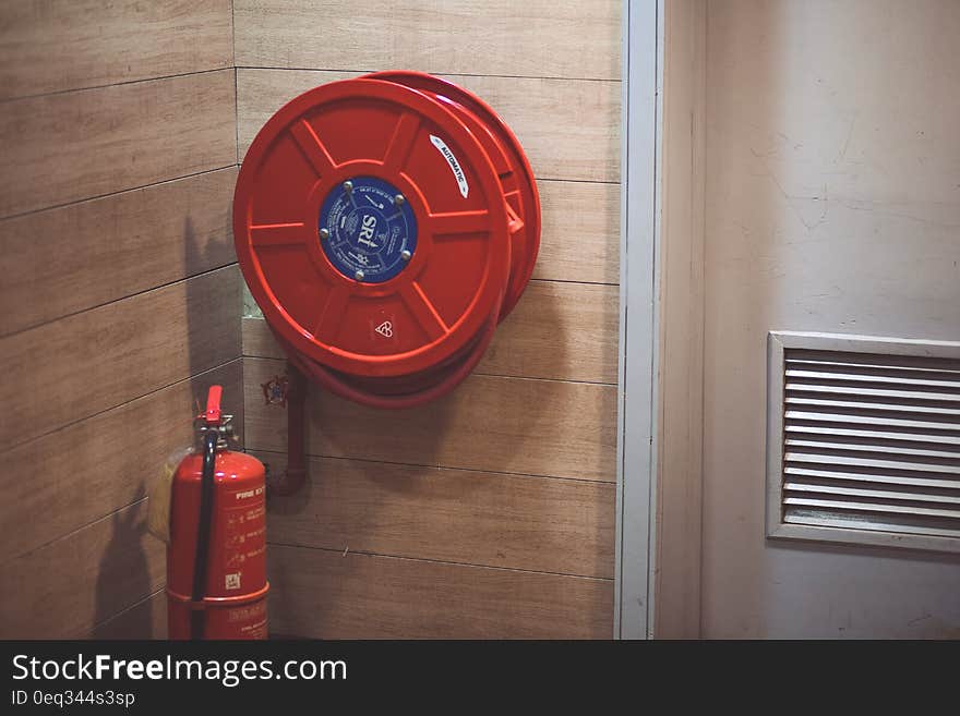 Red Fire Extinguisher Beside Hose Reel Inside the Room