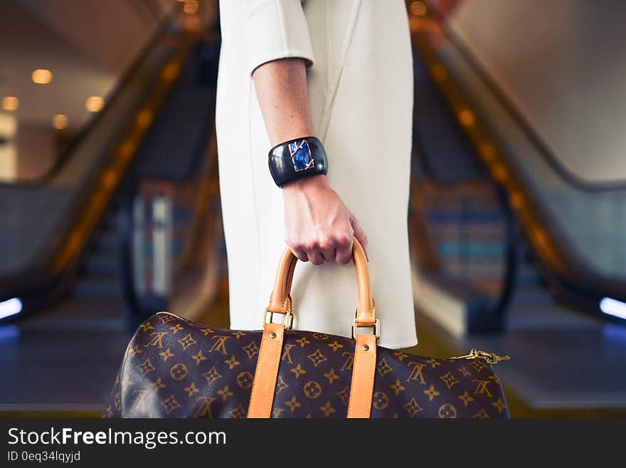 A woman traveling and carrying a fashion bag. A woman traveling and carrying a fashion bag