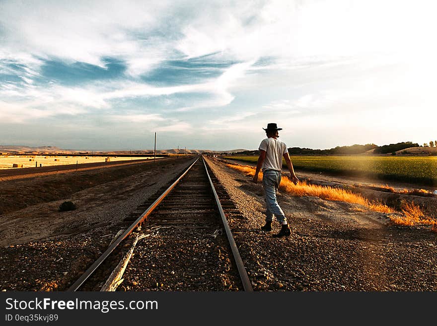 Traveler next to railroad tracks in a travel concept image. Traveler next to railroad tracks in a travel concept image