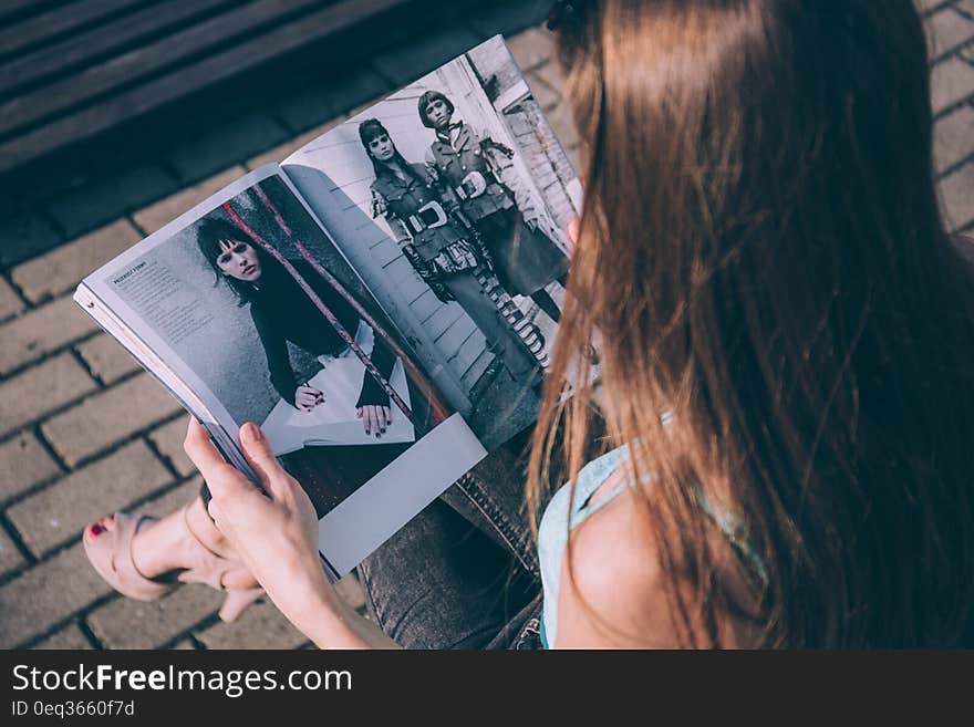 Brown Haired Female Reading Magazine