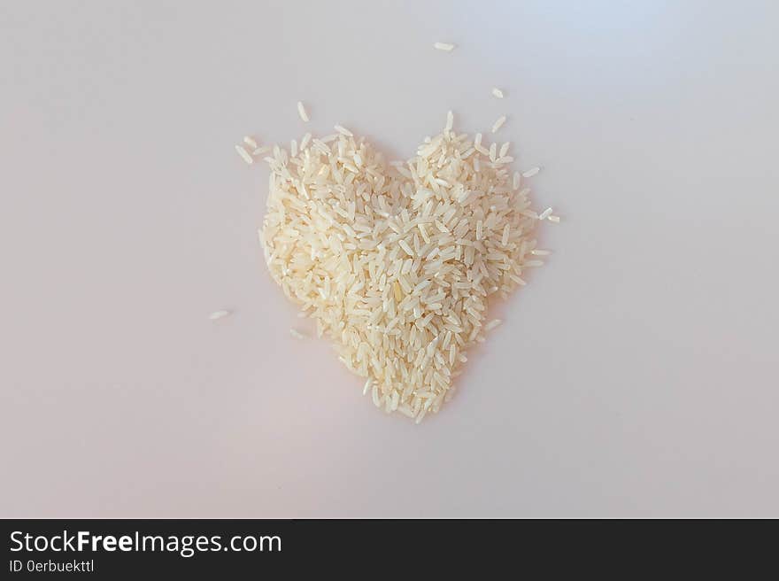 A pile of uncooked rice in form of a heart. A pile of uncooked rice in form of a heart