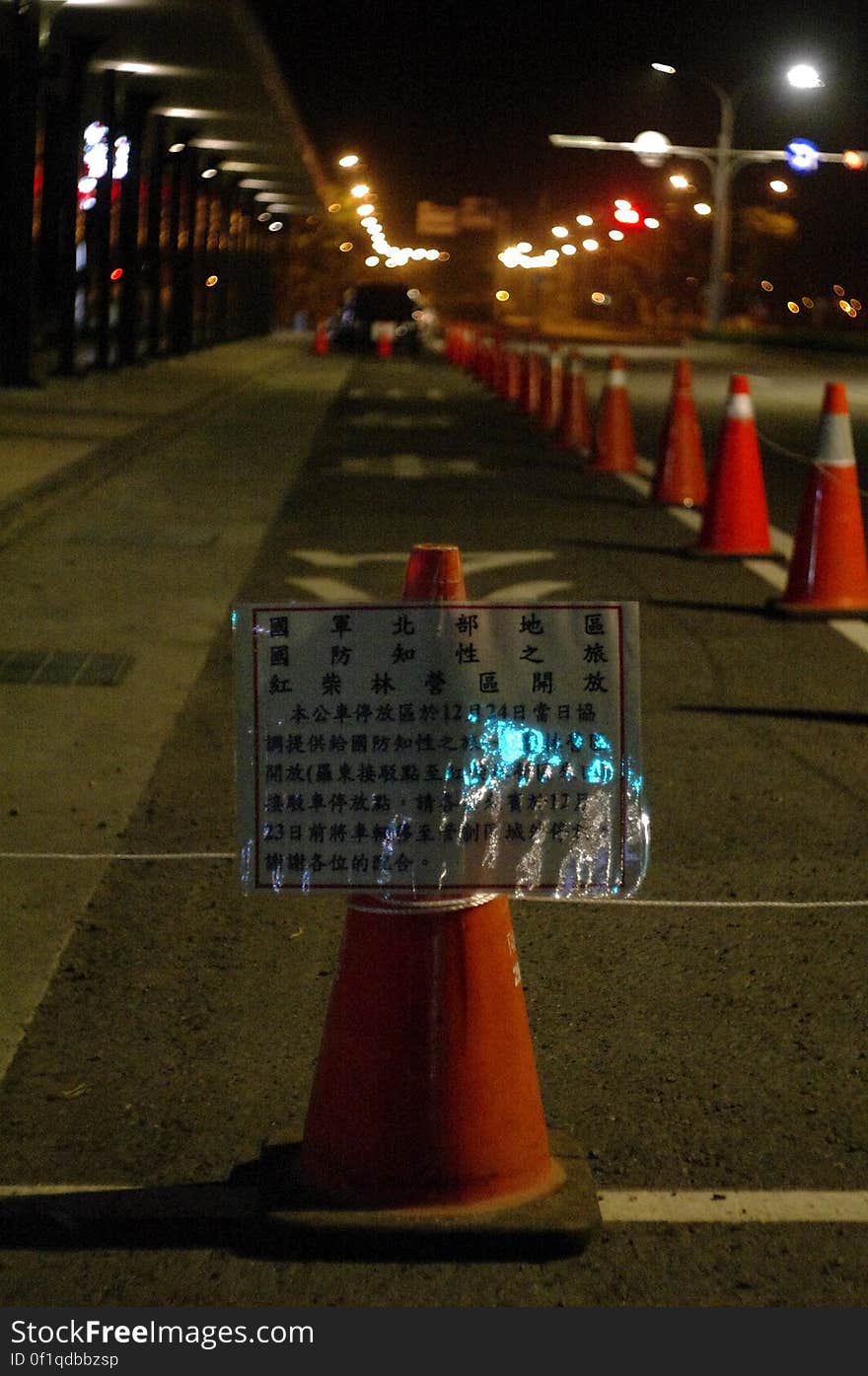 Orange traffic cones on side of street at night. Orange traffic cones on side of street at night.