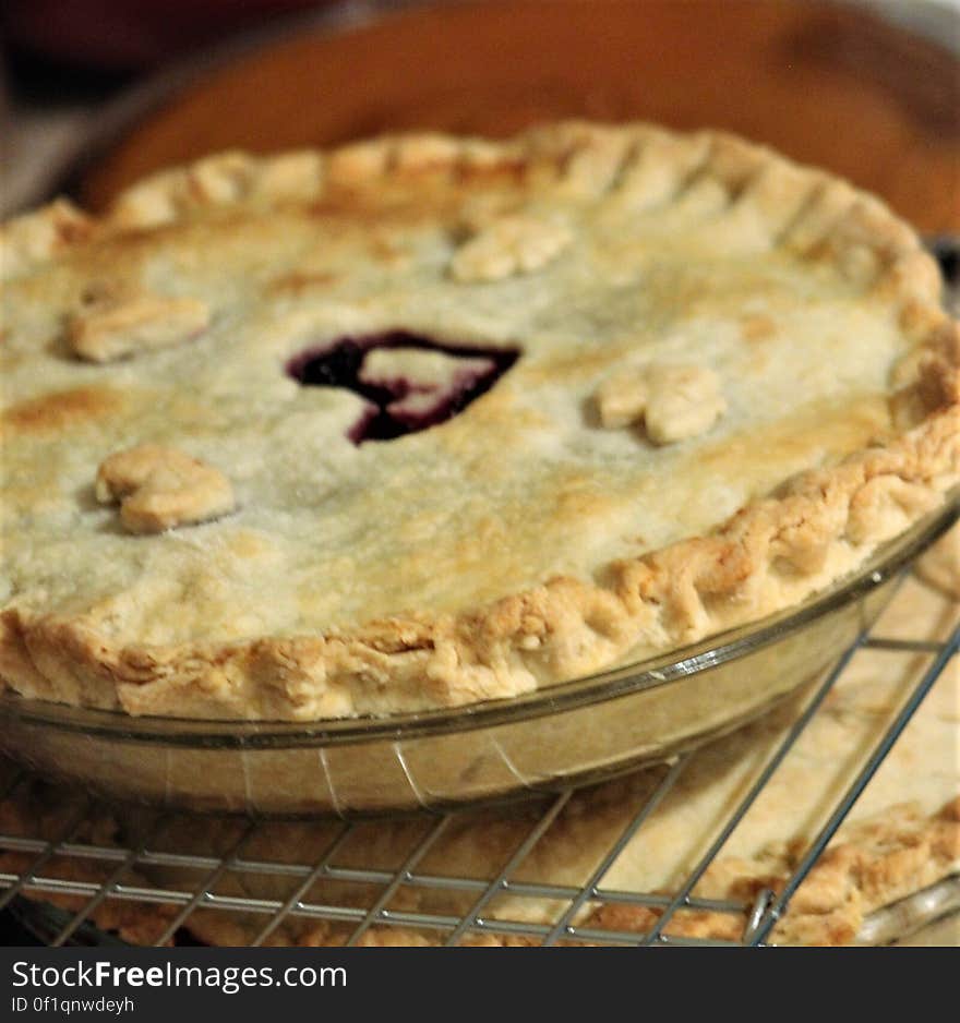 Cherry pie with heart in center, on rack with other pies. Cherry pie with heart in center, on rack with other pies