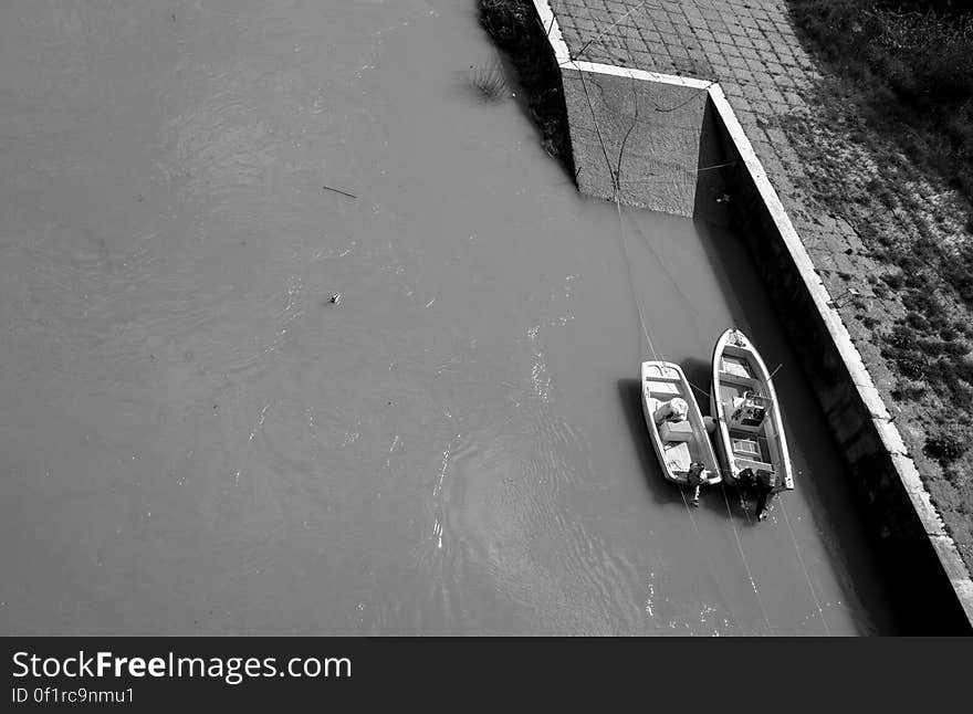 Wooden boats moored to waterfront in black and white. Wooden boats moored to waterfront in black and white.