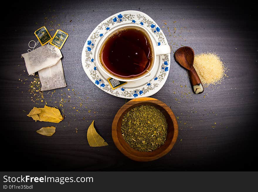 Coffee Served on White and Blue Ceramic Coffee Cup and Saucer Beside Brown Wooden Bowl