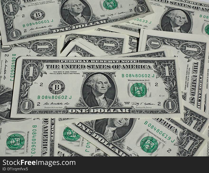 Pile of one Dollar bills with George Washington on the face of these United States currency notes.