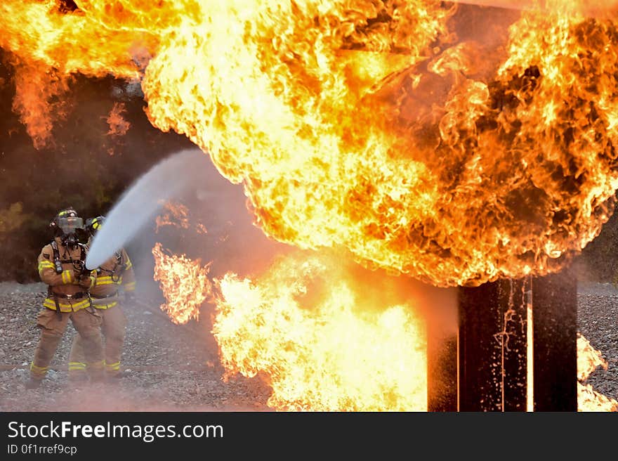 A pair of fire fighters putting out a conflagration.