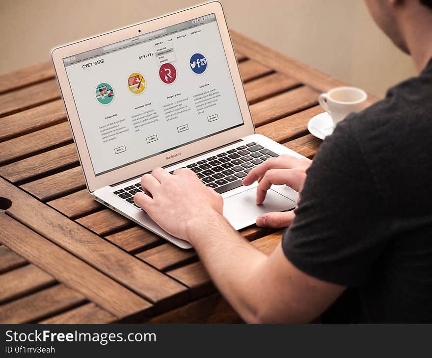 A man working on a laptop computer. A man working on a laptop computer.