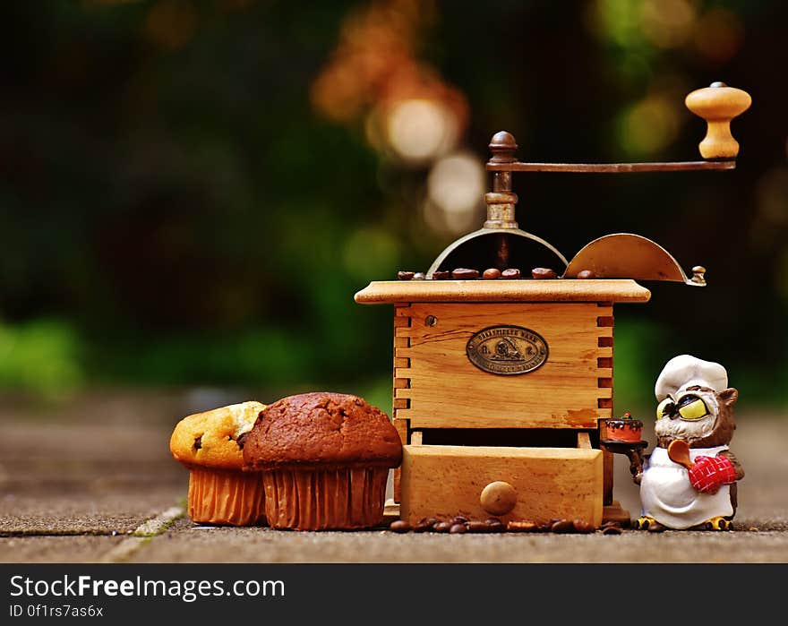 A vintage coffee mill and couple of cupcakes. A vintage coffee mill and couple of cupcakes.