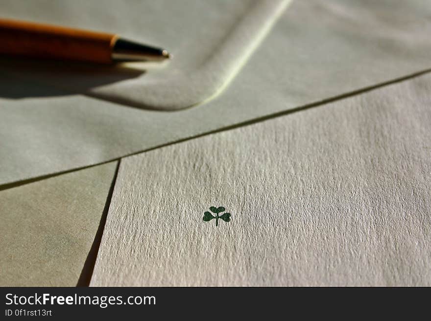 A drawing of a three leaved clover with an envelope and a pen. A drawing of a three leaved clover with an envelope and a pen.