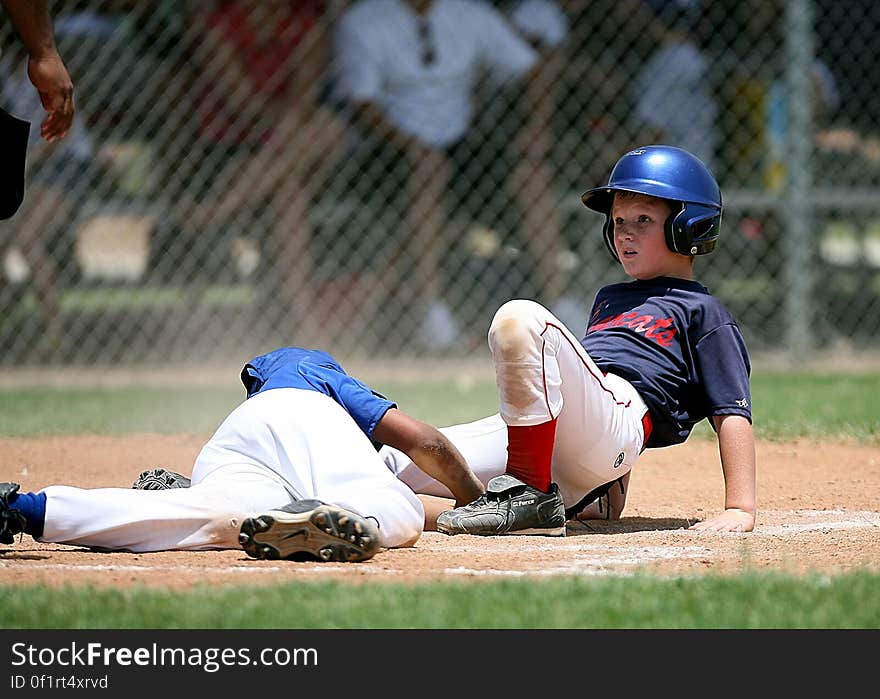 A softball player sliding into base with catcher. A softball player sliding into base with catcher.