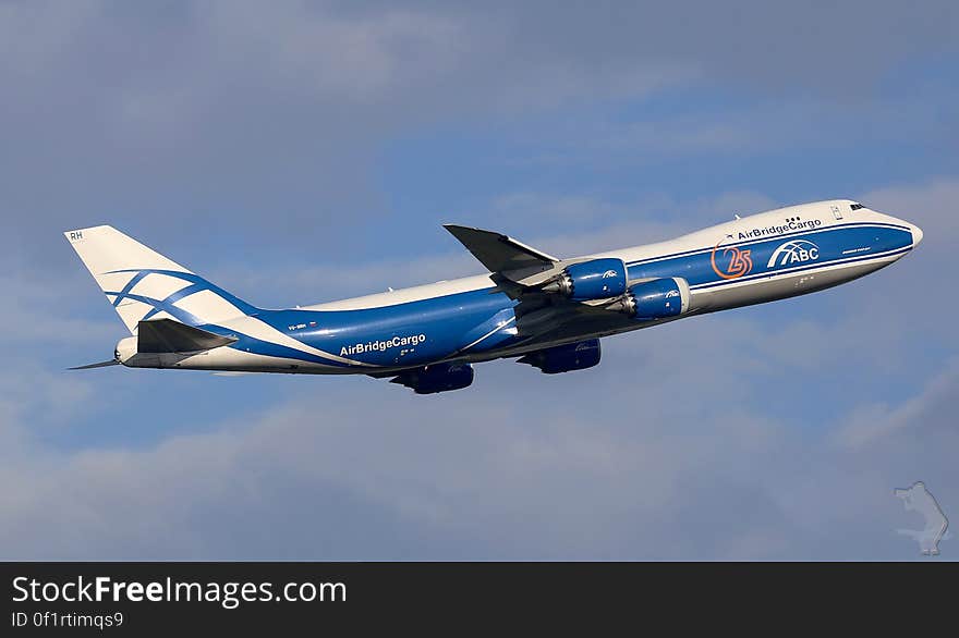 An AirBridgeCargo Boeing 747 plane taking off on blue skies.