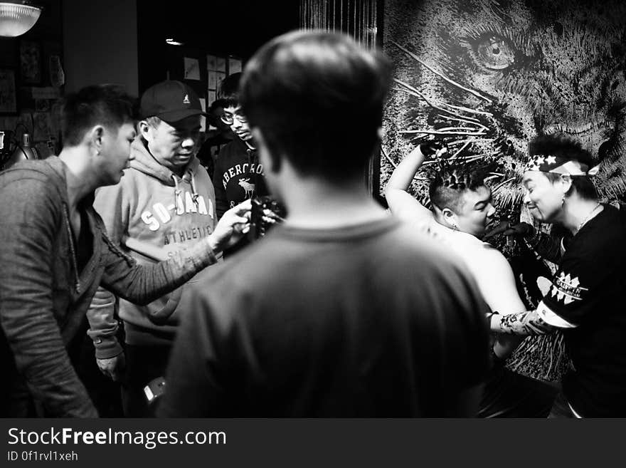 A group of Asian men in a tattoo parlor.