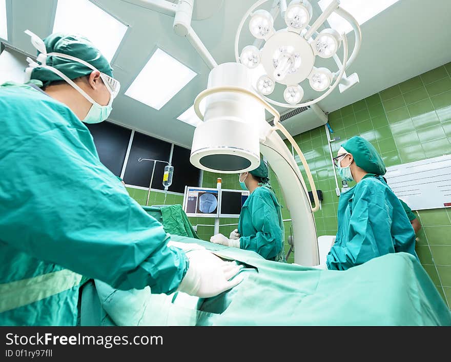 Doctors operating on a patient in an operating room. Doctors operating on a patient in an operating room.