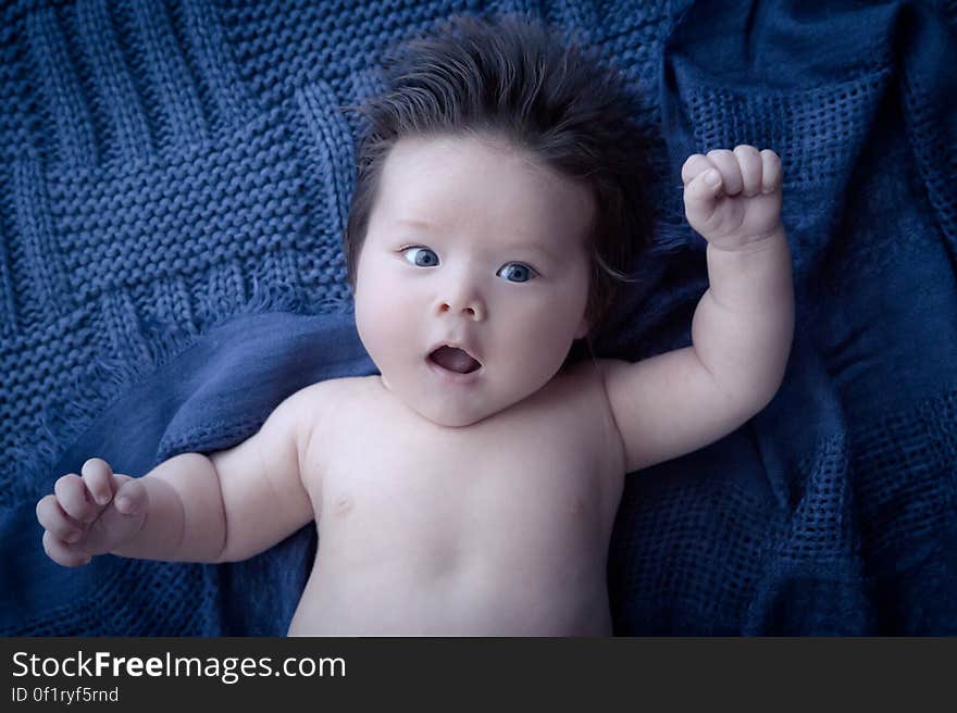 A baby boy lying on a blue woolen cover. A baby boy lying on a blue woolen cover.