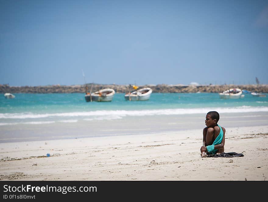 A young boy looks out over boats anchored off Lido Beach in the Kaaraan district of the Somali capital Mogadishu, 05 August, 2013. 06 August marks 2 years since the Al Qaeda-affiliated extremist group Al Shabaab withdrew from Mogadishu following sustained operations by forces of the Somali National Army &#x28;SNA&#x29; backed by troops of the African Union Mission in Somalia &#x28;AMISOM&#x29; to retake the city. Since the group&#x27;s departure the country&#x27;s captial has re-established itself and a sense of normality has returned. Buildings and infrastructure devastated and destroyed by two decades of conflict have been repaired; thousands of Diaspora Somalis have returned home to invest and help rebuild their nation; foreign embassies and diplomatic missions have reopened and for the first time in many years, Somalia has an internationally recognised government.. AU-UN IST PHOTO / STUART PRICE. A young boy looks out over boats anchored off Lido Beach in the Kaaraan district of the Somali capital Mogadishu, 05 August, 2013. 06 August marks 2 years since the Al Qaeda-affiliated extremist group Al Shabaab withdrew from Mogadishu following sustained operations by forces of the Somali National Army &#x28;SNA&#x29; backed by troops of the African Union Mission in Somalia &#x28;AMISOM&#x29; to retake the city. Since the group&#x27;s departure the country&#x27;s captial has re-established itself and a sense of normality has returned. Buildings and infrastructure devastated and destroyed by two decades of conflict have been repaired; thousands of Diaspora Somalis have returned home to invest and help rebuild their nation; foreign embassies and diplomatic missions have reopened and for the first time in many years, Somalia has an internationally recognised government.. AU-UN IST PHOTO / STUART PRICE.