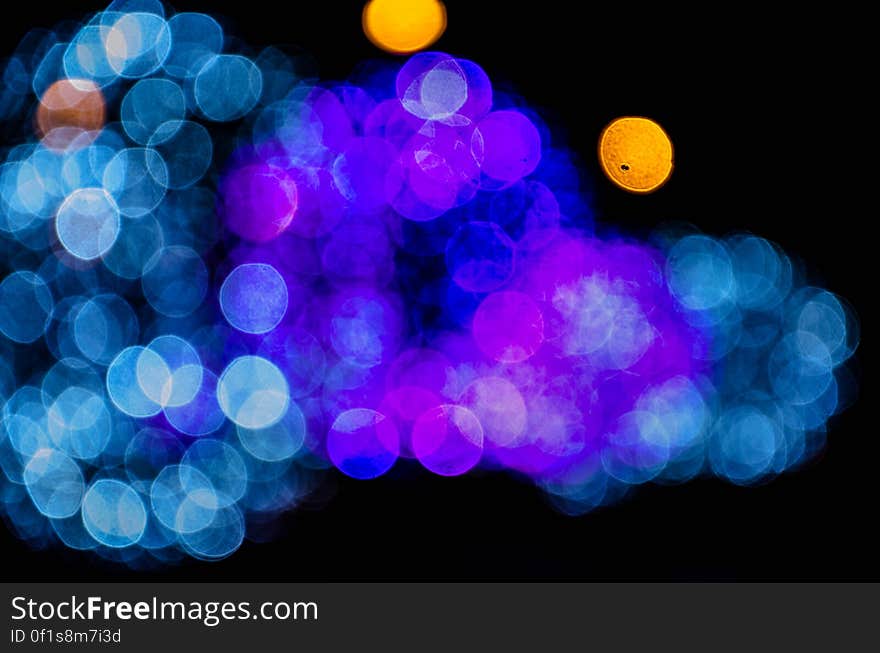 Blue and purple bokeh lights shining with black background.