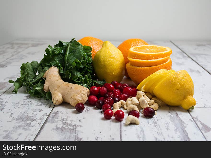 Lemon Orange Red Berries Ginger Peanut on Wooden Table