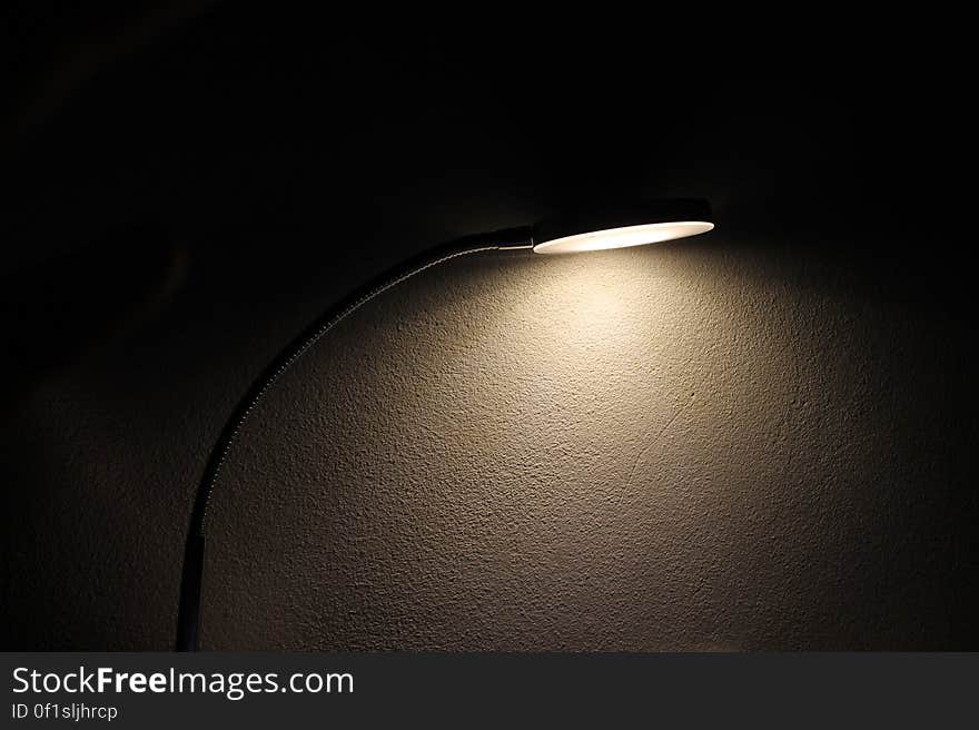 A table lamp shining light in the dark.