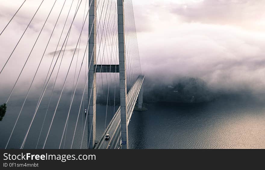 A large suspension bridge with cars crossing it.