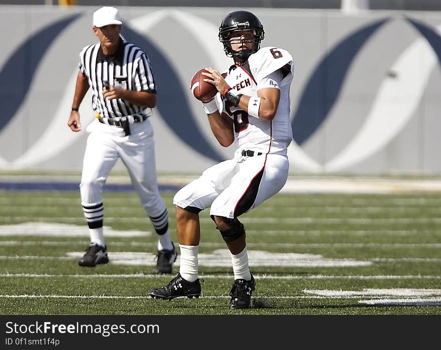 Football Playing Holding Football Near Referee