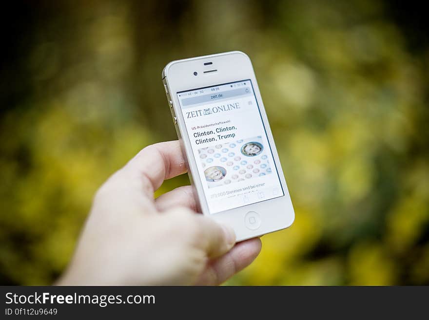 A modern smartphone with an electronic newspaper open. A modern smartphone with an electronic newspaper open.