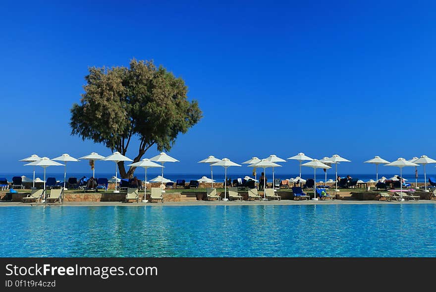 A sunny beach with umbrellas and sun chairs. A sunny beach with umbrellas and sun chairs.