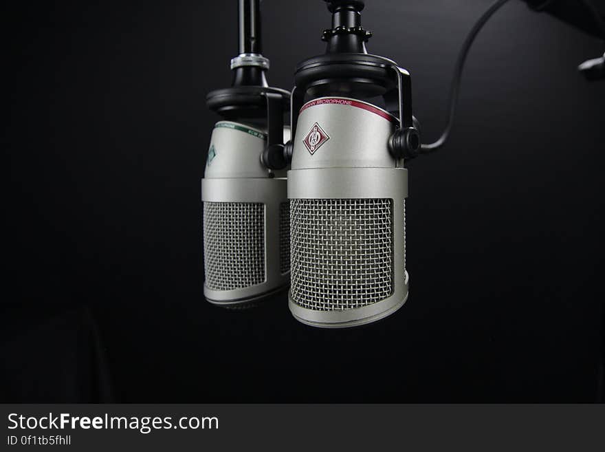 A pair of professional microphones on a black background.