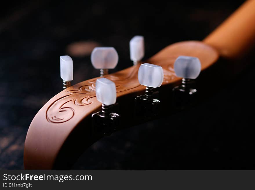 Classic guitar head and tuning pegs with artistic engraving.