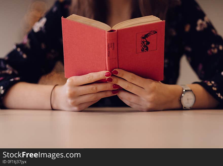 A girl reading a small red book. A girl reading a small red book.