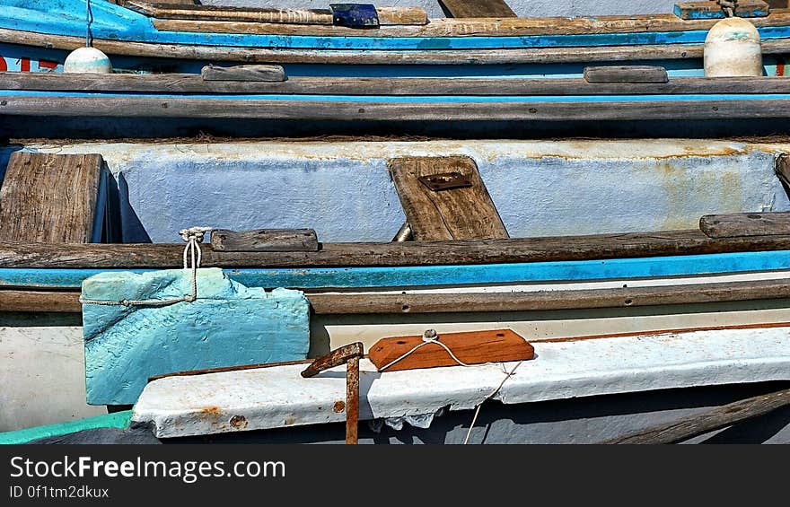 Wooden boats moored to pier on sunny day. Wooden boats moored to pier on sunny day.