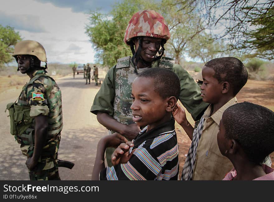 A Burundian soldier serving with the African Union Mission in Somalia &#x28;AMISOM&#x29; greets children in the village of Modmoday approx. 40km east of the central Somali town of Baidoa. The Burundians, together with forces of the Somali National Army &#x28;SNA&#x29; have been mounting &#x27;snap&#x27; foot patrols in villages and areas to the east of Baidoa where Al Qaeda-affiliated extremist group Al Shabaab mount attacks against local herdsmen, villages and travelers along the busy Baidoa-Mogadishu road. The AMISOM troops also use the patrols as an opportunity to provide occasional free medical treatment and fresh, potable drinking water for residents in the area. AU/UN IST PHOTO / ABDI DAKAN. A Burundian soldier serving with the African Union Mission in Somalia &#x28;AMISOM&#x29; greets children in the village of Modmoday approx. 40km east of the central Somali town of Baidoa. The Burundians, together with forces of the Somali National Army &#x28;SNA&#x29; have been mounting &#x27;snap&#x27; foot patrols in villages and areas to the east of Baidoa where Al Qaeda-affiliated extremist group Al Shabaab mount attacks against local herdsmen, villages and travelers along the busy Baidoa-Mogadishu road. The AMISOM troops also use the patrols as an opportunity to provide occasional free medical treatment and fresh, potable drinking water for residents in the area. AU/UN IST PHOTO / ABDI DAKAN.