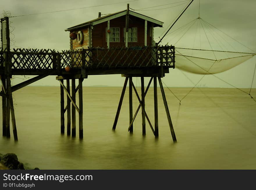 Boathouse on end of wooden dock with fishing nets. Boathouse on end of wooden dock with fishing nets.