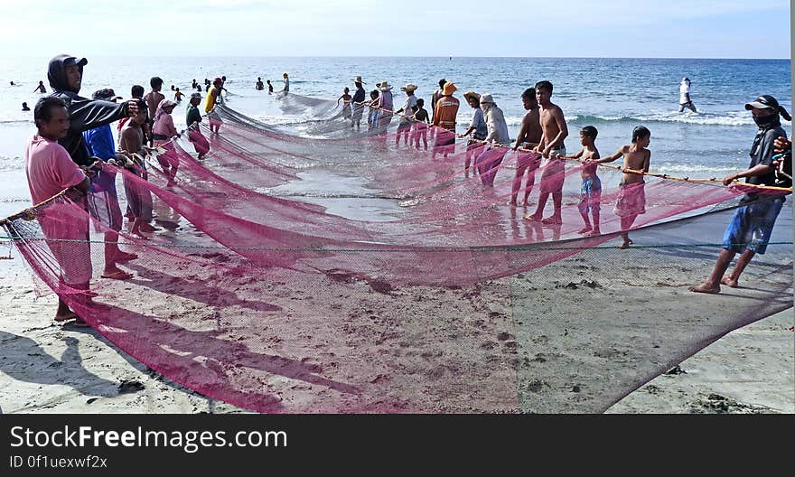 Fishermen pulling ashore there nets. Currimao beach.Philippines. Fishermen pulling ashore there nets. Currimao beach.Philippines.