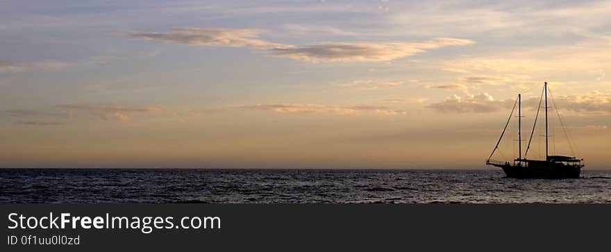 Panorama of sailboat on waters at sunset. Panorama of sailboat on waters at sunset.