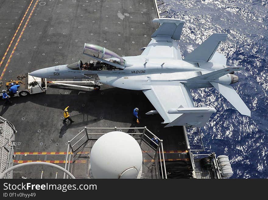 Sailors transport a Boeing EA-18G &#x22;Growler&#x22; assigned to the &#x27;Gauntlets&#x27; of Electronic Attack Squadron &#x28;VAQ&#x29; 136 onto an aircraft elevator aboard the USS Ronald Reagan &#x28;CVN 76&#x29;. Ronald Reagan is en route to Hawaii for Rim of the Pacific &#x28;RIMPAC&#x29; 2014. Twenty-three nations, more than 40 ships and submarines, more than 200 aircraft and 25,000 personnel are participating in the biennial RIMPAC exercise from June 26 to Aug. 1-un-edited-Not part of my personal collection