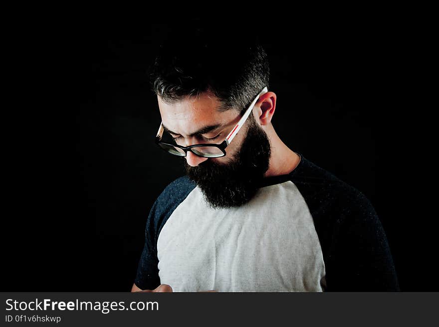 Studio portrait of man with beard wearing glasses with serious expression. Studio portrait of man with beard wearing glasses with serious expression.