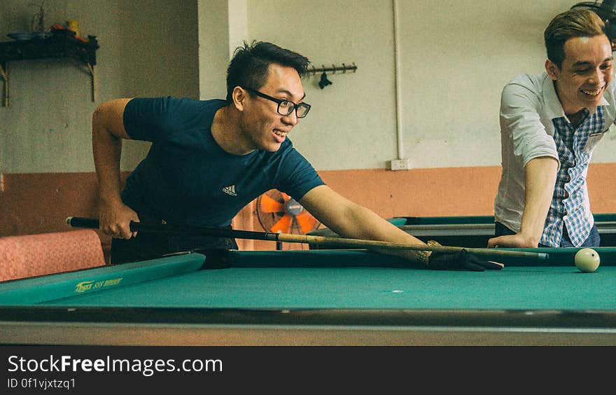 Men playing laughing and playing pool. Men playing laughing and playing pool.