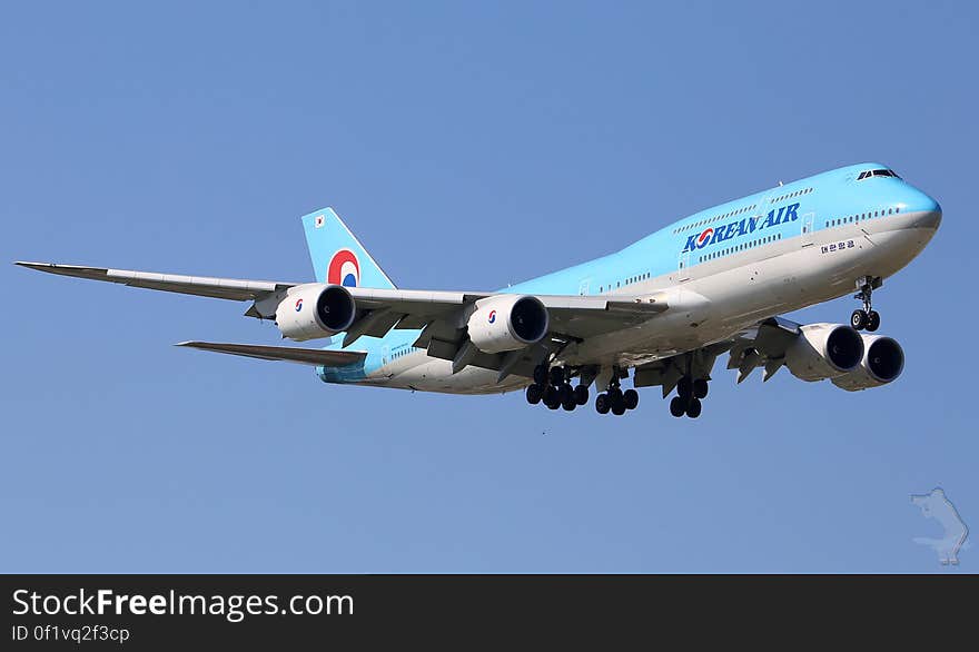 Korean Air commercial airliner in flight against blue skies. Korean Air commercial airliner in flight against blue skies.