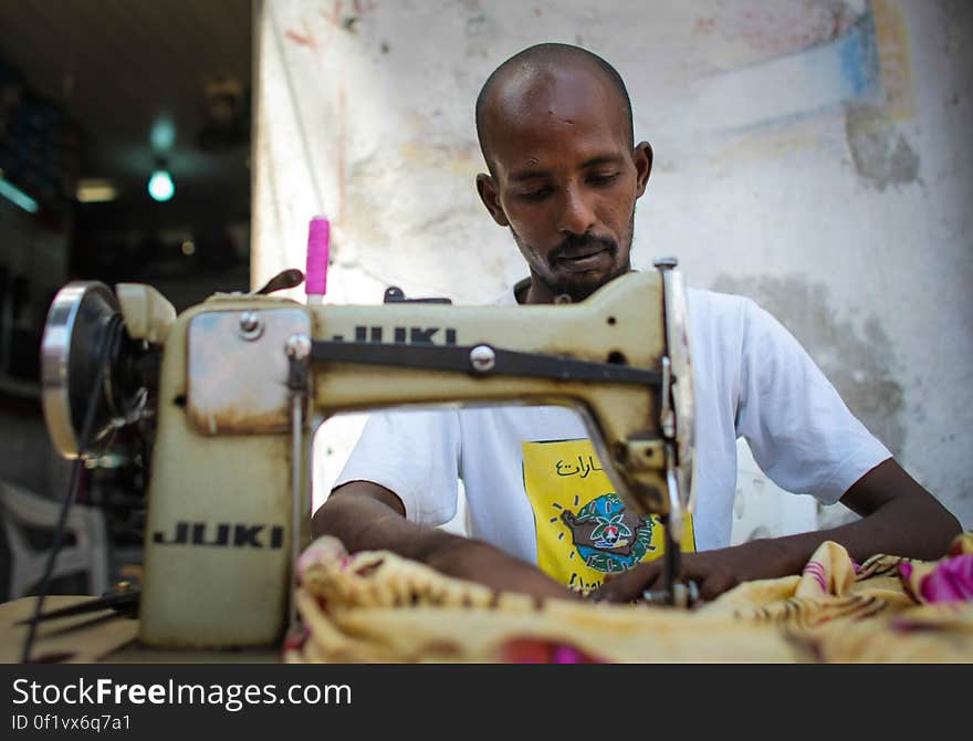 A tailor works on the street outside his shop in Hamar Weyne market in the Somali capital Mogadishu, 05 August, 2013. 06 August marks 2 years since the Al Qaeda-affiliated extremist group Al Shabaab withdrew from Mogadishu following sustained operations by forces of the Somali National Army &#x28;SNA&#x29; backed by troops of the African Union Mission in Somalia &#x28;AMISOM&#x29; to retake the city. Since the group&#x27;s departure the country&#x27;s captial has re-established itself and a sense of normality has returned. Buildings and infrastructure devastated and destroyed by two decades of conflict have been repaired; thousands of Diaspora Somalis have returned home to invest and help rebuild their nation; foreign embassies and diplomatic missions have reopened and for the first time in many years, Somalia has an internationally recognised government.. AU-UN IST PHOTO / STUART PRICE. A tailor works on the street outside his shop in Hamar Weyne market in the Somali capital Mogadishu, 05 August, 2013. 06 August marks 2 years since the Al Qaeda-affiliated extremist group Al Shabaab withdrew from Mogadishu following sustained operations by forces of the Somali National Army &#x28;SNA&#x29; backed by troops of the African Union Mission in Somalia &#x28;AMISOM&#x29; to retake the city. Since the group&#x27;s departure the country&#x27;s captial has re-established itself and a sense of normality has returned. Buildings and infrastructure devastated and destroyed by two decades of conflict have been repaired; thousands of Diaspora Somalis have returned home to invest and help rebuild their nation; foreign embassies and diplomatic missions have reopened and for the first time in many years, Somalia has an internationally recognised government.. AU-UN IST PHOTO / STUART PRICE.