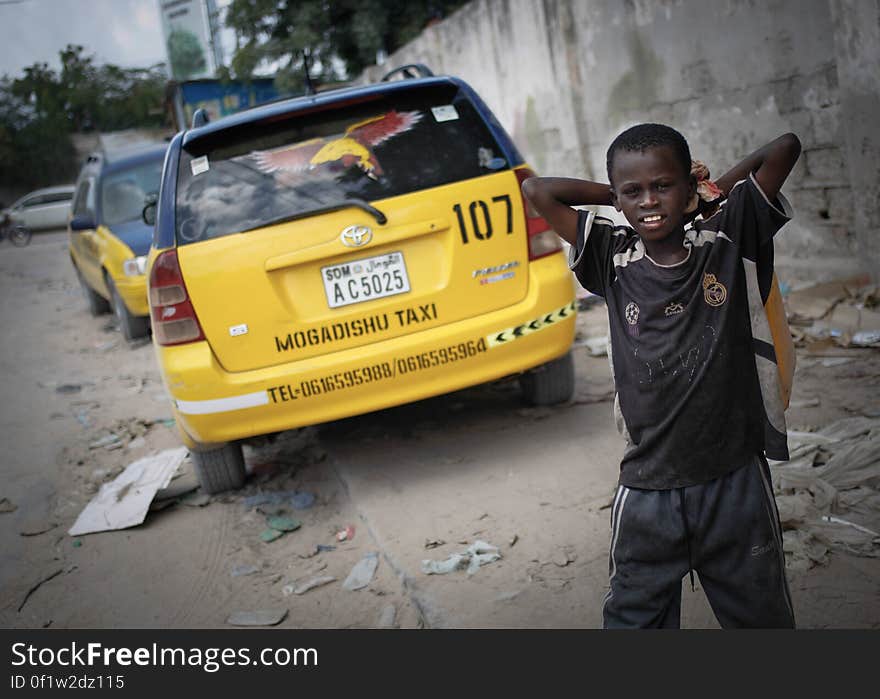 A young boy stands next to cars of the Mogadishu Taxi Company next to the company&#x27;s head office in the Somali capital Mogadishu, 01 September 2013. Operating since the end of May of this year in the city&#x27;s dusty and once again bustling streets and thoroughfares, the MTC&#x27;s distinctive yellow and purple cars offer customers taxi fares around Mogadishu at competitive rates and in the first 3 months of operations, the company has increased it&#x27;s fleet of vehicles from an initial 25 to over 100. The company, according to one of it&#x27;s drivers, also enables employment opportunities for Somalia&#x27;s youth following two decades of conflict in the Horn of Africa nation that shattered a generation. Now, thanks to the relative peace that has followed the departure of the Al-Qaeda-affiliated extremist group Al Shabaab from the city; an internationally recognised government for the first time in years and thousands of Diaspora Somalis returning home to invest in and rebuild their country, the MTC is one of many new companies establishing itself in the new Mogadishu and offering services that were hitherto impossible to provide. AU-UN IST PHOTO / STUART PRICE. A young boy stands next to cars of the Mogadishu Taxi Company next to the company&#x27;s head office in the Somali capital Mogadishu, 01 September 2013. Operating since the end of May of this year in the city&#x27;s dusty and once again bustling streets and thoroughfares, the MTC&#x27;s distinctive yellow and purple cars offer customers taxi fares around Mogadishu at competitive rates and in the first 3 months of operations, the company has increased it&#x27;s fleet of vehicles from an initial 25 to over 100. The company, according to one of it&#x27;s drivers, also enables employment opportunities for Somalia&#x27;s youth following two decades of conflict in the Horn of Africa nation that shattered a generation. Now, thanks to the relative peace that has followed the departure of the Al-Qaeda-affiliated extremist group Al Shabaab from the city; an internationally recognised government for the first time in years and thousands of Diaspora Somalis returning home to invest in and rebuild their country, the MTC is one of many new companies establishing itself in the new Mogadishu and offering services that were hitherto impossible to provide. AU-UN IST PHOTO / STUART PRICE.