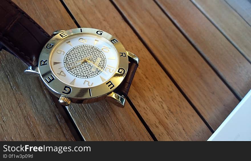 A Geiger wrist watch on a wooden table.