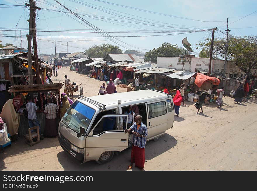 SOMALIA, Kismayo: In a photograph taken 15 July 2013 and released by the African Union-United Nations Information Support Team 22 July, a man alights from a commuter taxi as an African Union Mission in Somalia &#x28;AMISOM&#x29; convoy passes throught the centre of Kismayo in southern Somalia. AU-UN IST PHOTO / RAMADAN MOHAMED HASSAN. SOMALIA, Kismayo: In a photograph taken 15 July 2013 and released by the African Union-United Nations Information Support Team 22 July, a man alights from a commuter taxi as an African Union Mission in Somalia &#x28;AMISOM&#x29; convoy passes throught the centre of Kismayo in southern Somalia. AU-UN IST PHOTO / RAMADAN MOHAMED HASSAN.