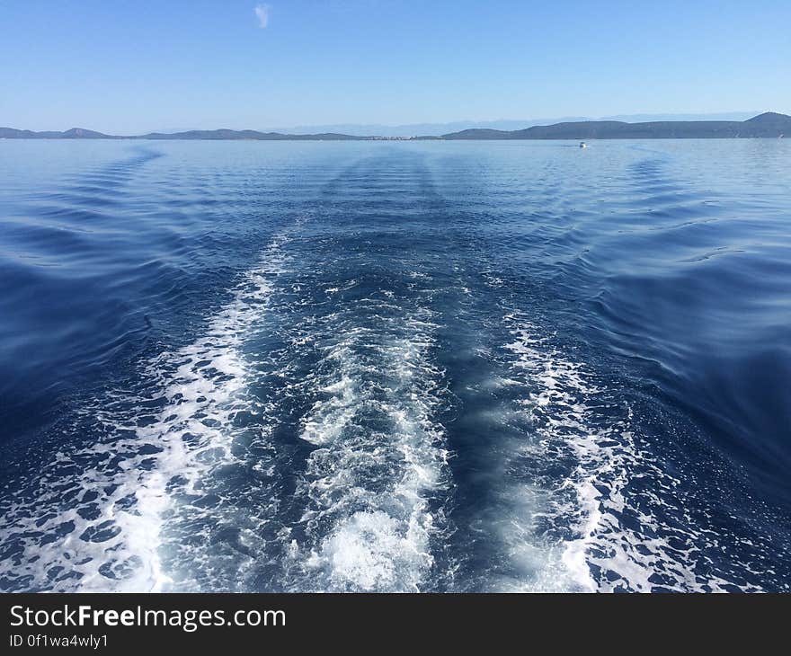 A foamy boat trail in the water. A foamy boat trail in the water.